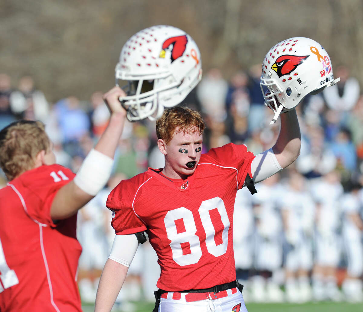Alex McMurray, left, and Joe Kelly, right, of Greenwich raise their helmets before the start of the 2012 FCIAC championship.