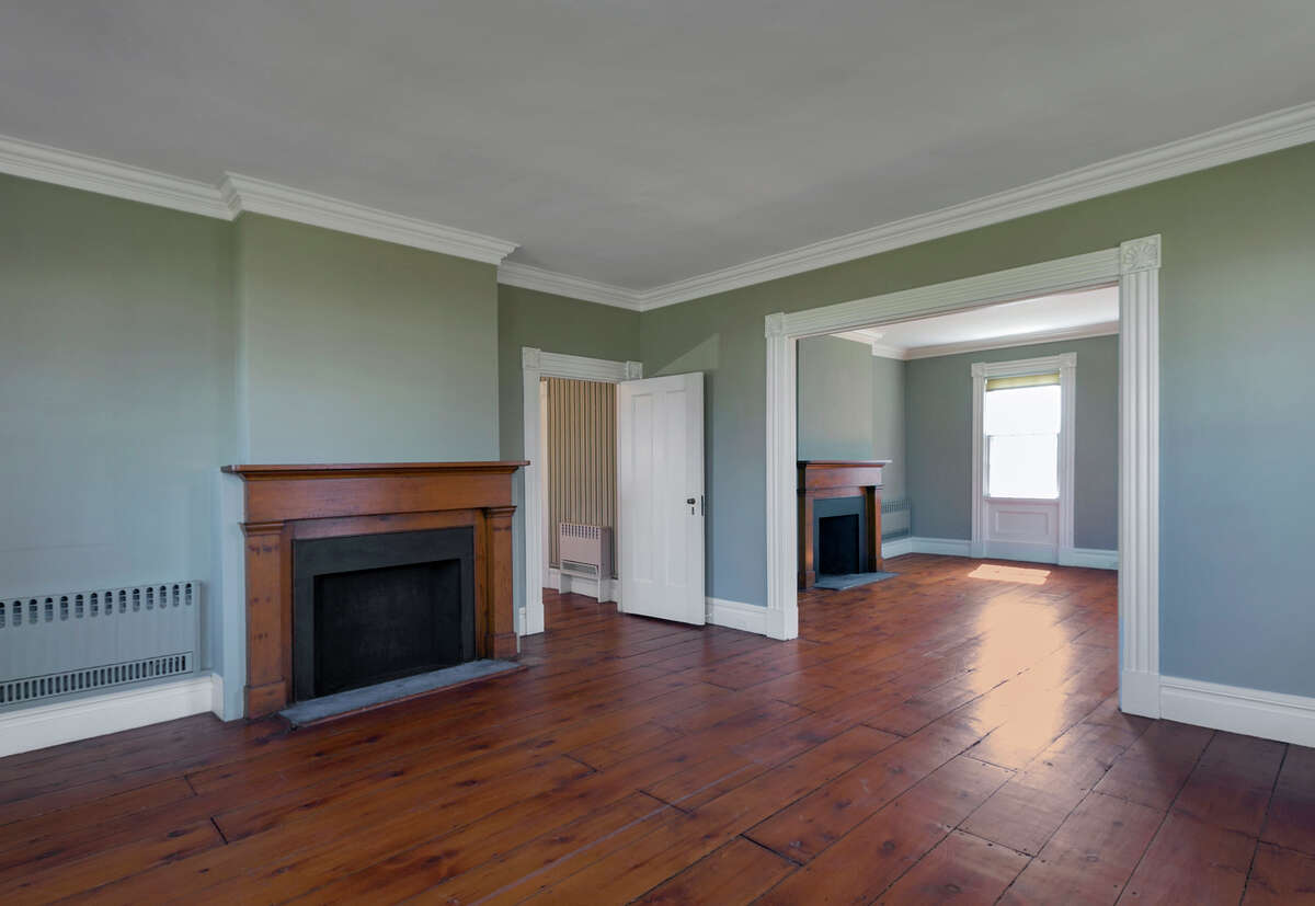 The living room area -- two rooms in one -- features two of the seven fireplaces in the house at 104 Old South Road.