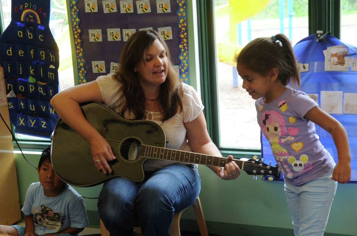 Teacher Stephanie Strazza sings with Jhayda Perez at Family Centers Head Start preschools at Armstrong Court in Greenwich, Conn., on Monday, June, 10, 2013.