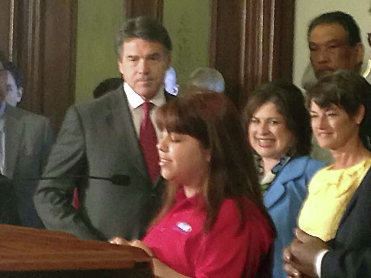 Cristina Salais introduces Gov. Rick Perry as he prepares to sign education reform bills into law. Salais is enrolled in the Alamo Colleges Information Technology Security Academy.