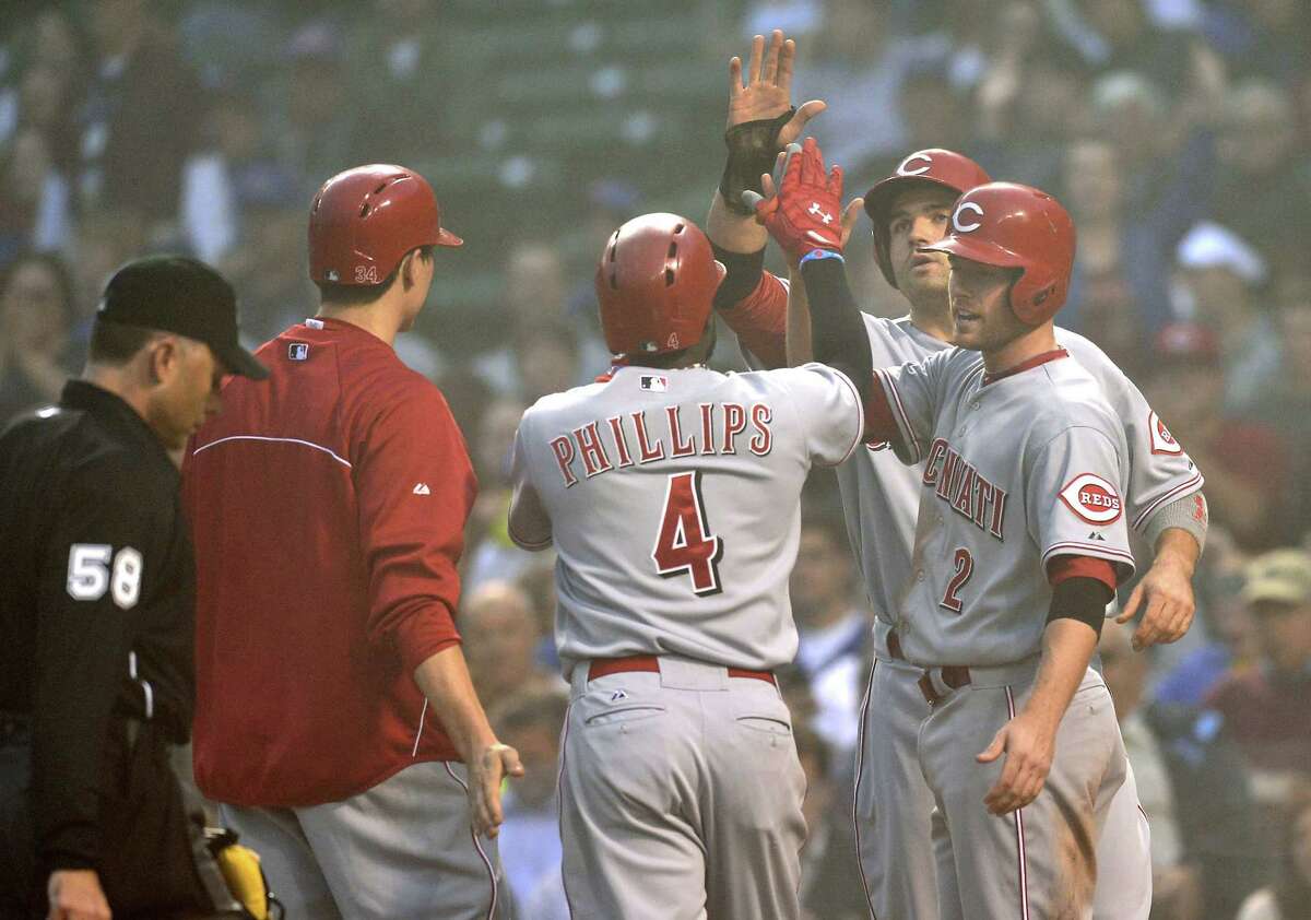 The Reds' Brandon Phillips (center) gets high-fives from teammates after hitting a grand slam.