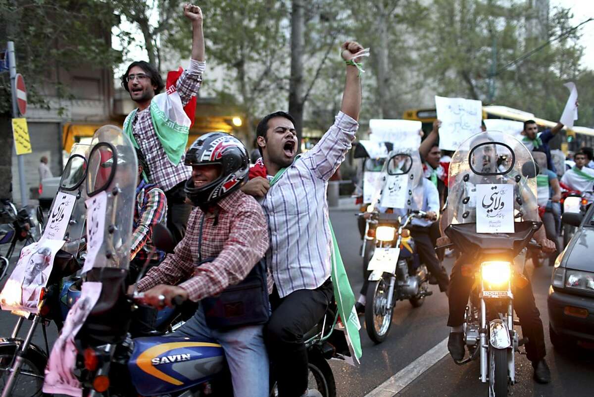 Supporters of the Iranian presidential candidate Ali Akbar Velayati, a conservative former foreign minister, chant slogans, during a street campaign, in Tehran, Iran,Tuesday, June 11, 2013. The presidential election will be held on June 14. (AP Photo/Ebrahim Noroozi)