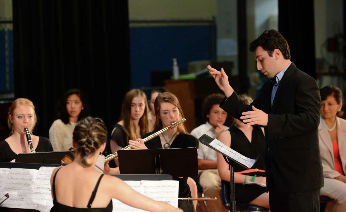 Paul Frucht, right, conducts "Dawn," a musical arrangement dedicated to former Assistant Principal and Honor Society Advisor Dawn Hochsprung, at the Junior Honor Society induction at Rogers Park Middle School in Danbury, Conn. on Tuesday, June 11, 2013. Frucht, a student a the Juilliard School and former Danbury resident, wrote the song for Dawn, who was killed in the Dec. 14 shooting at Sandy Hook Elementary School.