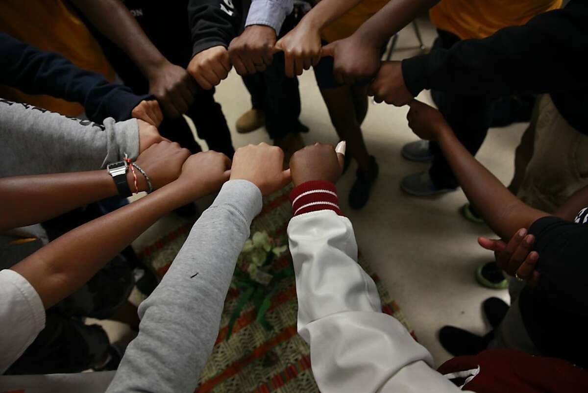 Kyle McClerkins, Restorative Justice coordinator, has students link thumbs to form a circle during a closing exercise on the last day that McClerkins met with the students for the school year at James Madison Middle school on Tuesday, June 11, 2013 in Oakland, Calif.