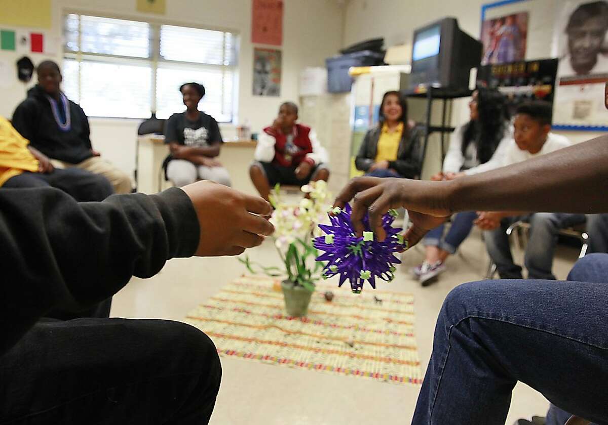 Elijah Miller (right), 14 receives the talking piece from Brandon Garcia (left), 13 on the last day that Kyle McClerkins (not shown), Restorative Justice coordinator, met with students during the school year at James Madison Middle school on Tuesday, June 11, 2013 in Oakland, Calif.
