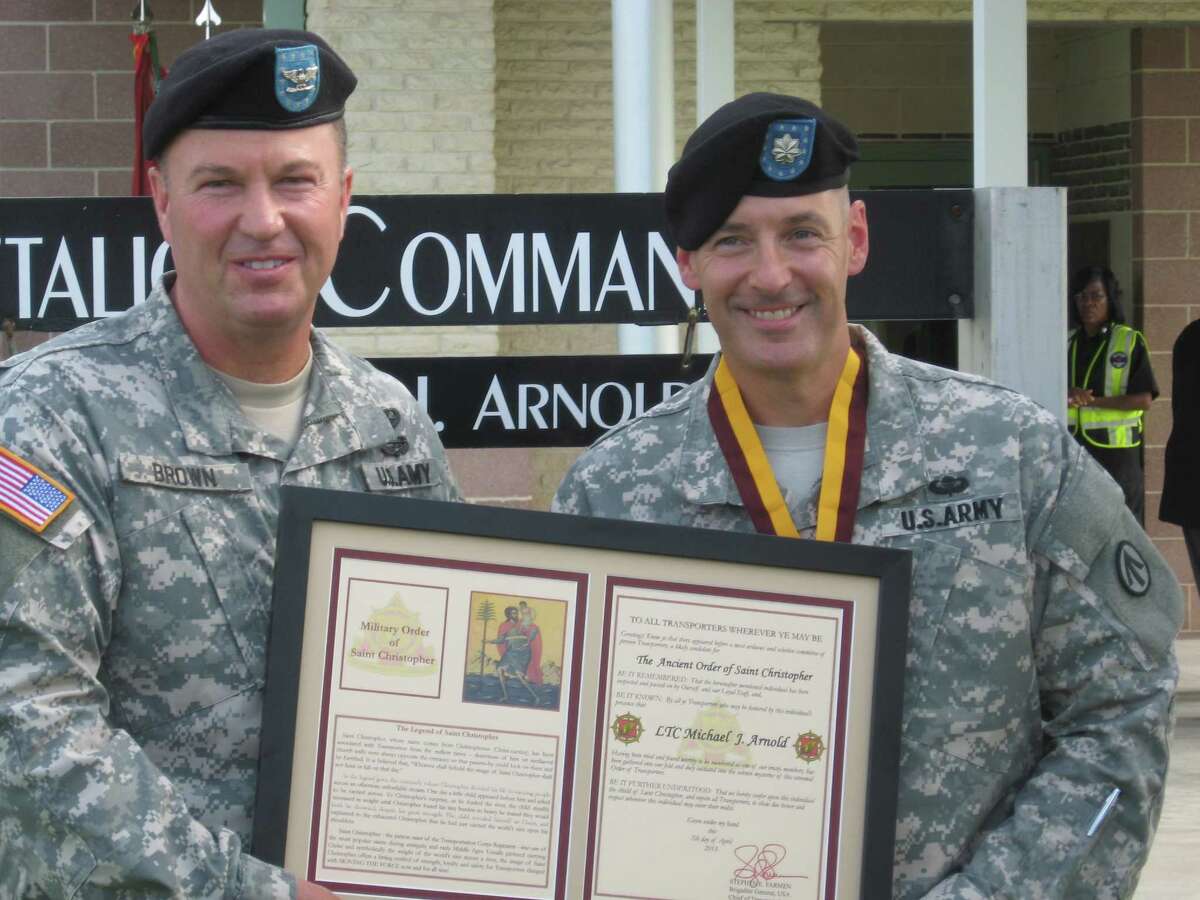 Army Col. Charles Brown, brigade commander of the 597th Transportation Brigade of Fort Eustis, Va., presents the Military Order of St. Christopher and the Army Meritorious Service Medal to Lt. Col. Michael J. Arnold, outgoing commander of the 842nd Transportation Battalion at the Port of Beaumont. Arnold led the battalion for two years and is transferring to the Army's Second Infantry Division in South Korea. His replacement at the 842nd is Lt. Col. Darren Bowser. Dan Wallach/The Enterprise