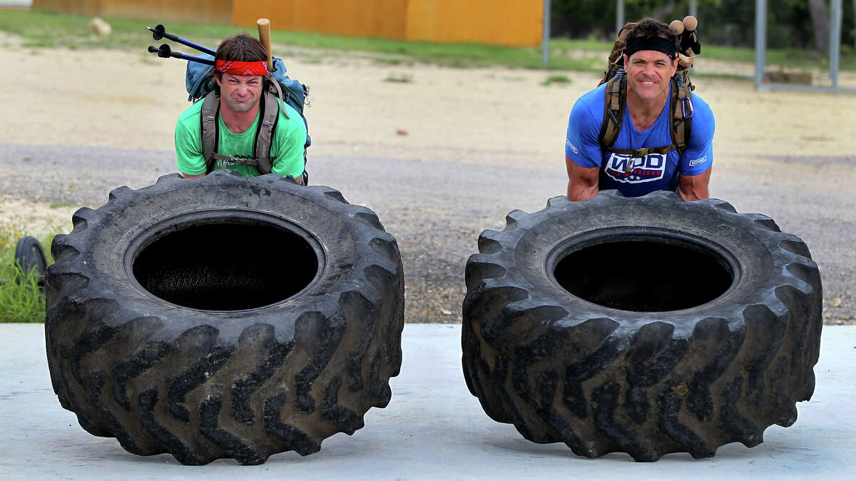 Marc Miller (left) and Brandon Bonser lift giant tractor tires Wednesday June 12, 2013 at Comal CrossFit while training for the Spartan Death Race in Vermont. The race is an adventure race with extreme physical challenges such as carrying large loads, climbing mountains, sitting in frigid water and felling trees.