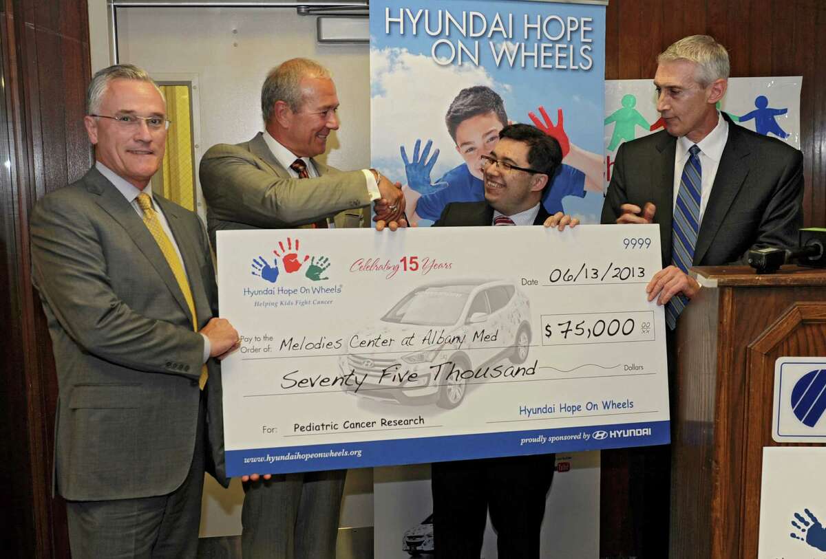 Dr. Alexander Gozman, second from right, receives a check for $75,000 for his work, which includes reducing stress in parents of children with cancer at Albany Medical Center on Thursday, June 13, 2013 in Albany, N.Y. The grant came from the Hyundai Hope On Wheels program and was presented by (L to R) Sean Garvey and Marc Garvey of Garvey Hyundai and Dave O'Brien, Hyundai regional sales manager. (Lori Van Buren / Times Union)