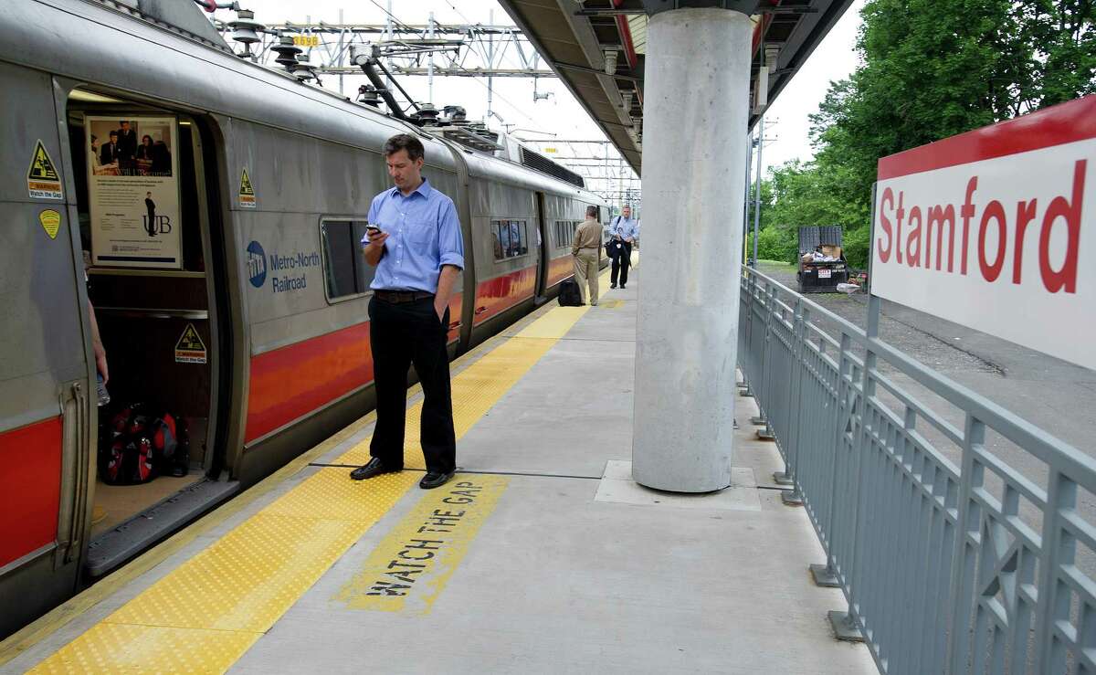 Passengers stand on the platform at Stamford's train station as their east-bound train waits for a rail bridge in Norwalk to be repaired after it was stuck in the up position on Friday, June 14, 2013.