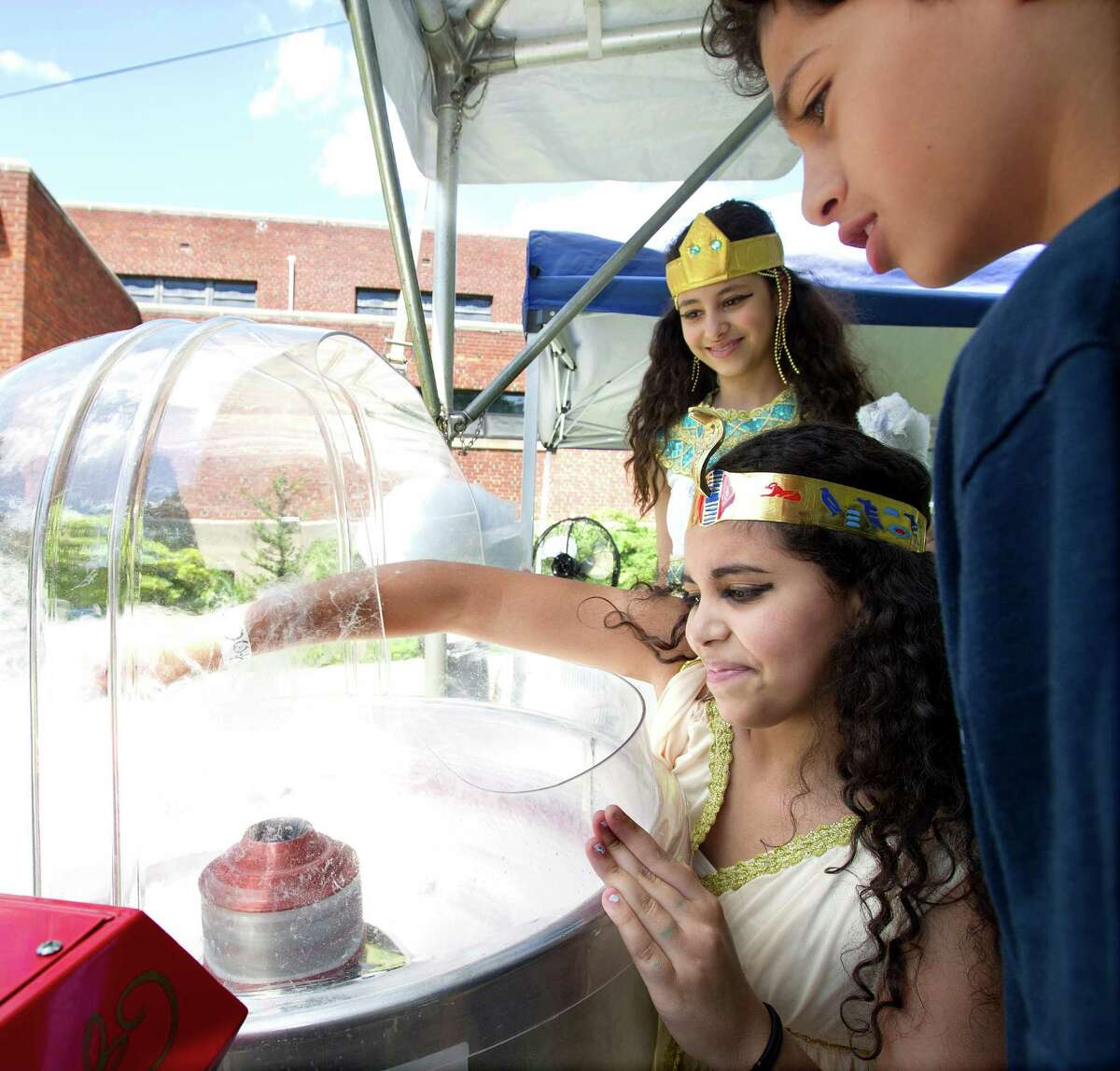 From back to front, Isabella Sorial, 12, Michelle Awad, 12, and Daniel Sorial, 10, make cotton candy during "A Taste of Egypt" at St. Peter and St. Andrew Coptic Orthodox Church in Stamford, Conn., on Saturday, June 15, 2013.