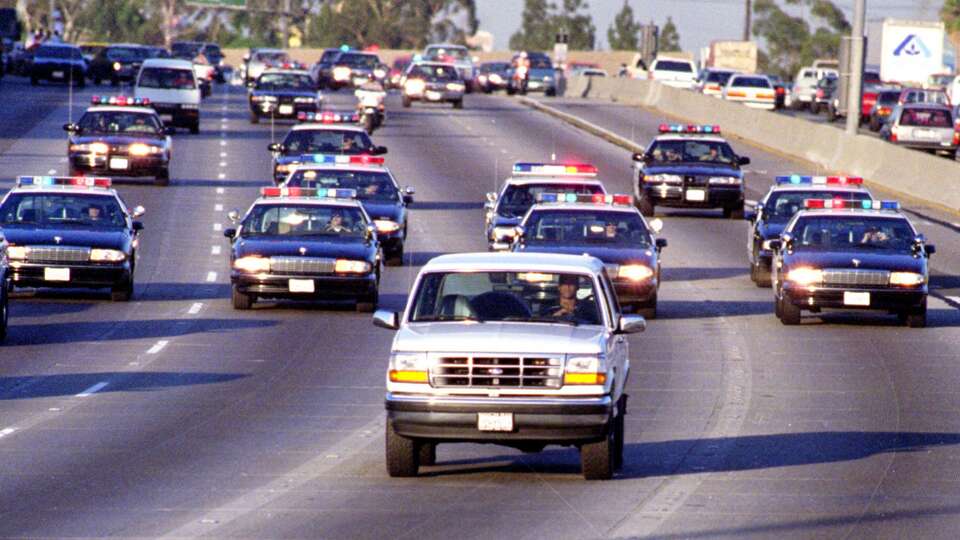 California Highway Patrol officers follow a Ford Bronco driven by Al Cowlings in Los Angeles as O.J. Simpson hides in the rear seat. Simpson's subsequent trial became a national obsession. 