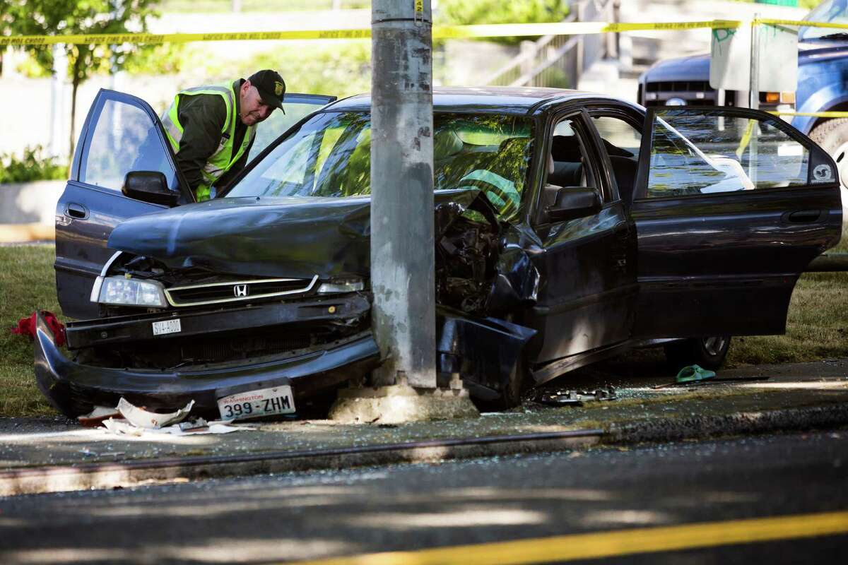 Police investigate the scene of a one-vehicle collision with a pole that left two children injured, including a 7-year-old girl who was transported to Harborview Medical Center Monday, June 17, 2013, just south of the intersection of 23rd Avenue and East Jefferson Street in Seattle. The northbound lanes of 23rd Avenue were shut down during an on-scene investigation, which is still ongoing.