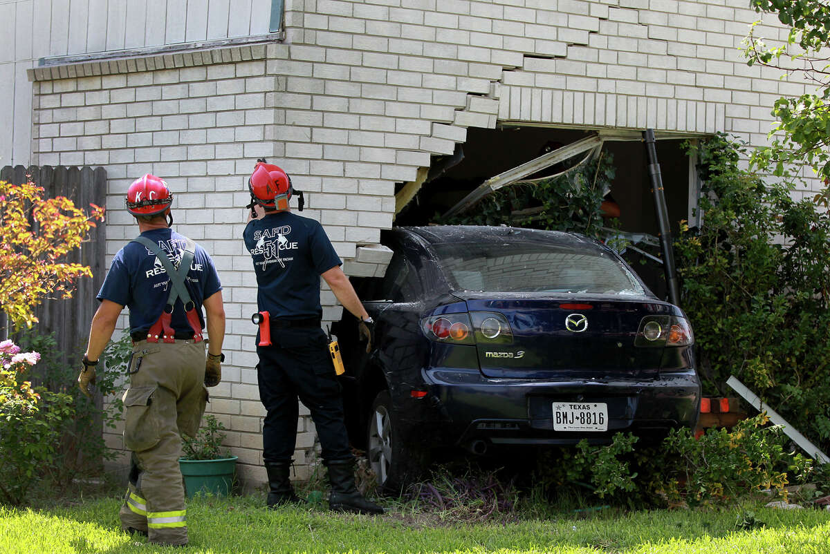 San Antonio firefighters inspect a home located at 15,530 Spring Summit after a four-door Mazda crashed into it Tuesday June 18, 2013. The car's driver, John Rodiguez, allegedly fell asleep while driving the vehicle and was not seiously injured. Homeowner Carlos Zapata,62, was at work at the time of the accident and after arriving at the scene said, "nobody got hurt, thank God for that."