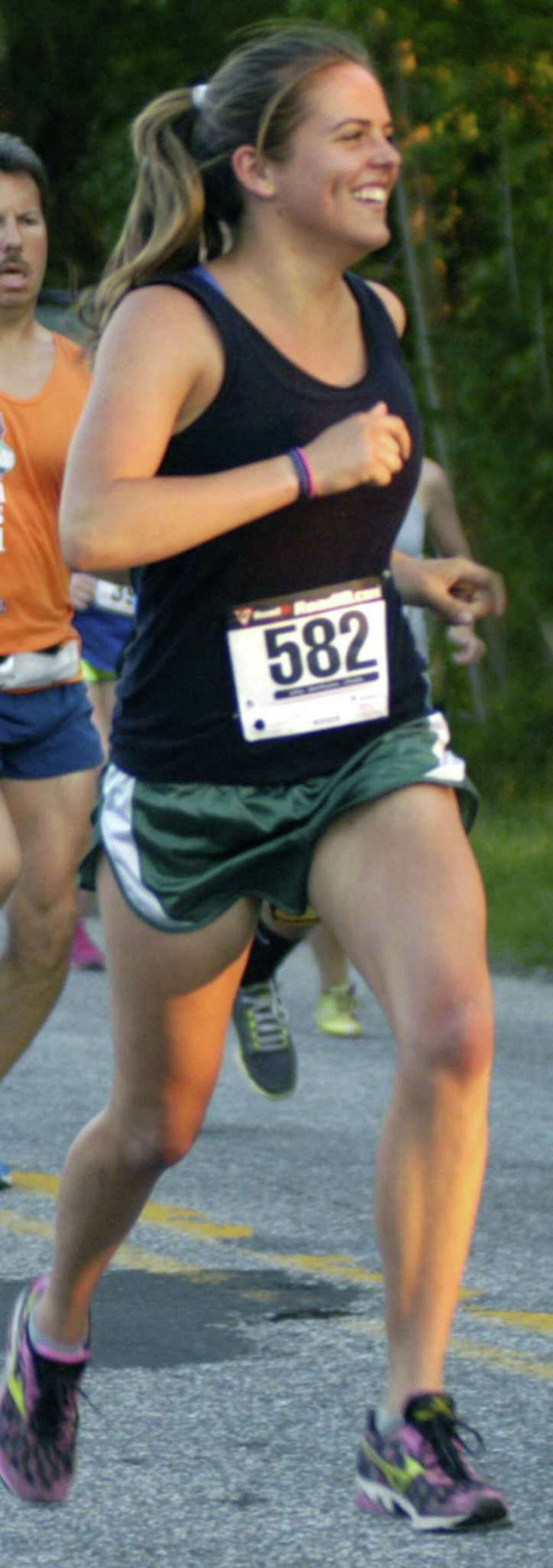 Stephanie Tyler, a 2009 graduate of New Milford High, sports a smile en route to second place among women's competitors in the second annual Bank Street Theater Twilight Run 5K road race in New Milford. May 31, 2013