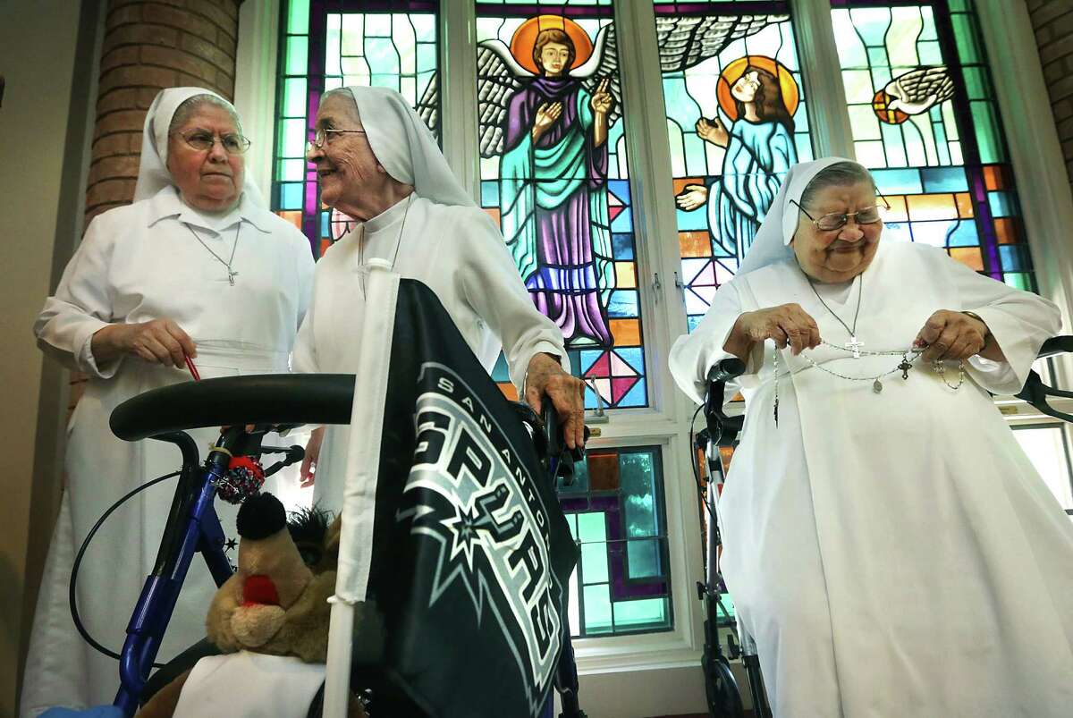 Sister Angelita Guzman (right) reacts to a humorous exchange between Sisters Guadalupe Medina (left) and Sister Rosalba Garcia, 85, while discussing the Salesian Sisters' love for the Spurs.