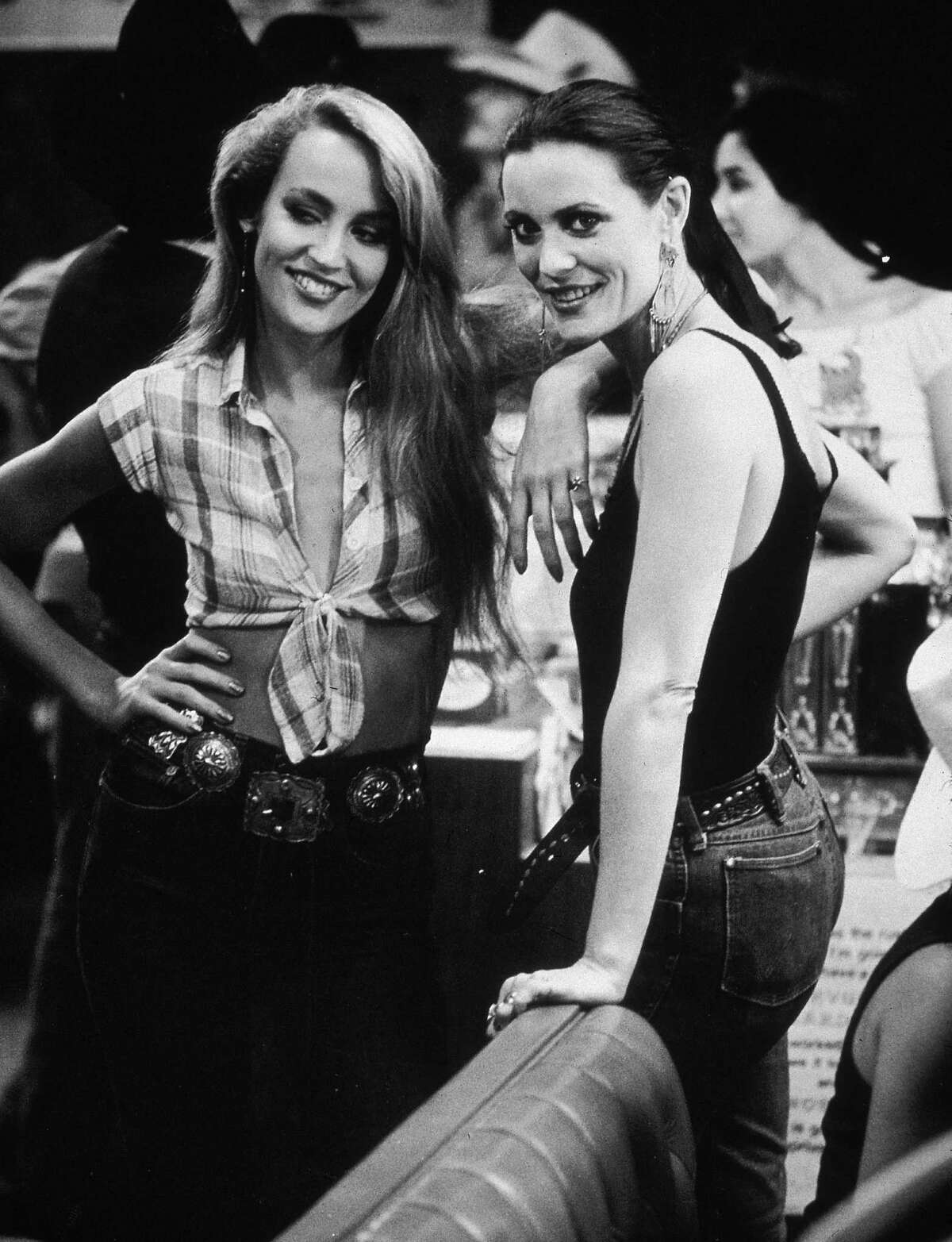 1980, American model and actor Jerry Hall and her sister, Cindy, at a party for director James Bridges's film 'Urban Cowboy' held at Gilley's, in Pasadena, Texas.