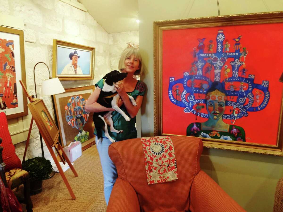 Kathy Sosa takes a break in a Southtown studio. Next to her is one of the paintings from her “Trees of Life” series, which is among her works exhibited at Semmes Library through June 31.