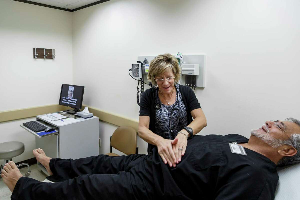Nurse practitioner Laura Rooney examines Roel Martinez at the health services clinic.