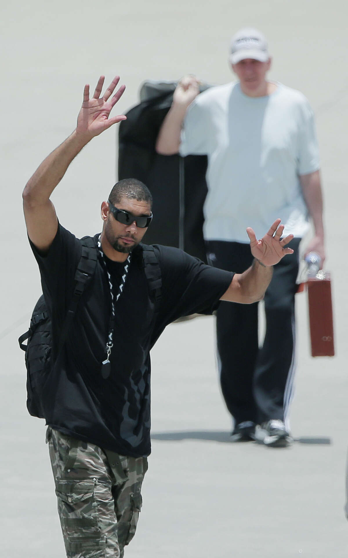 San Antonio Spurs' Tim Duncan, left, with head coach Gregg Popovich, rear right, waves to fans after the team returned home from losing to the Miami Heat in the NBA Finals basketball game, Friday, June 21, 2013, in San Antonio. (AP Photo/Eric Gay)