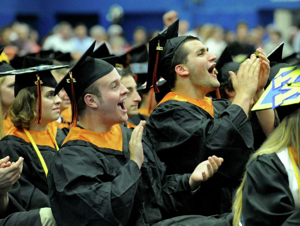 Patrick Barton, left, and Andrew Barton cheer fellow graduates as they receive their diplomas Friday afternoon. Ridgefield High School holds its graduation ceremony Friday, June 21, 2013, at the O'Neill Center at Western Connecticut State University in Danbury, Conn.