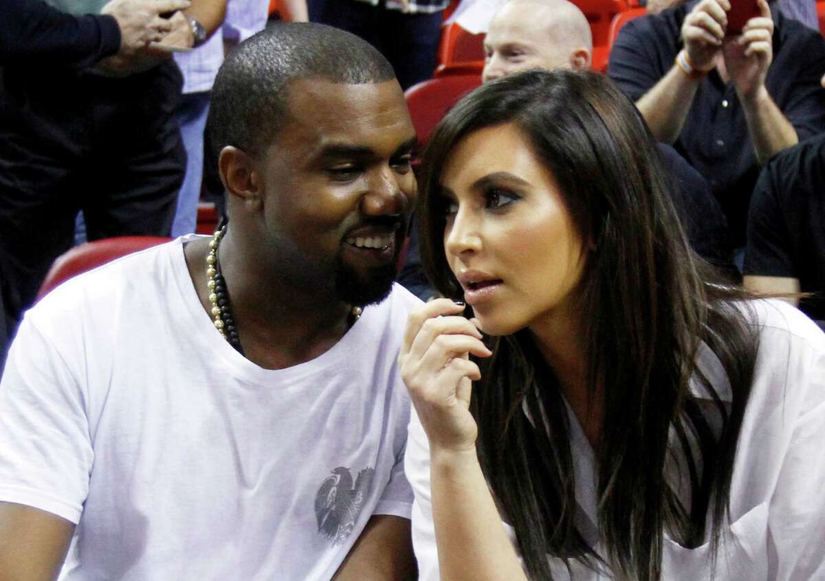 FILE - This Dec. 6, 2012 file photo shows singer Kanye West, left, talks to his girlfriend Kim Kardashian before an NBA basketball game between the Miami Heat and the New York Knicks in Miami. A birth certificate released by the Los Angeles County Dept. of Public Health shows that the couple's daughter North west, was born on Saturday, June 15, 2013 at Cedars-Sinai Medical Center in Los Angeles. (AP Photo/Alan Diaz, file)