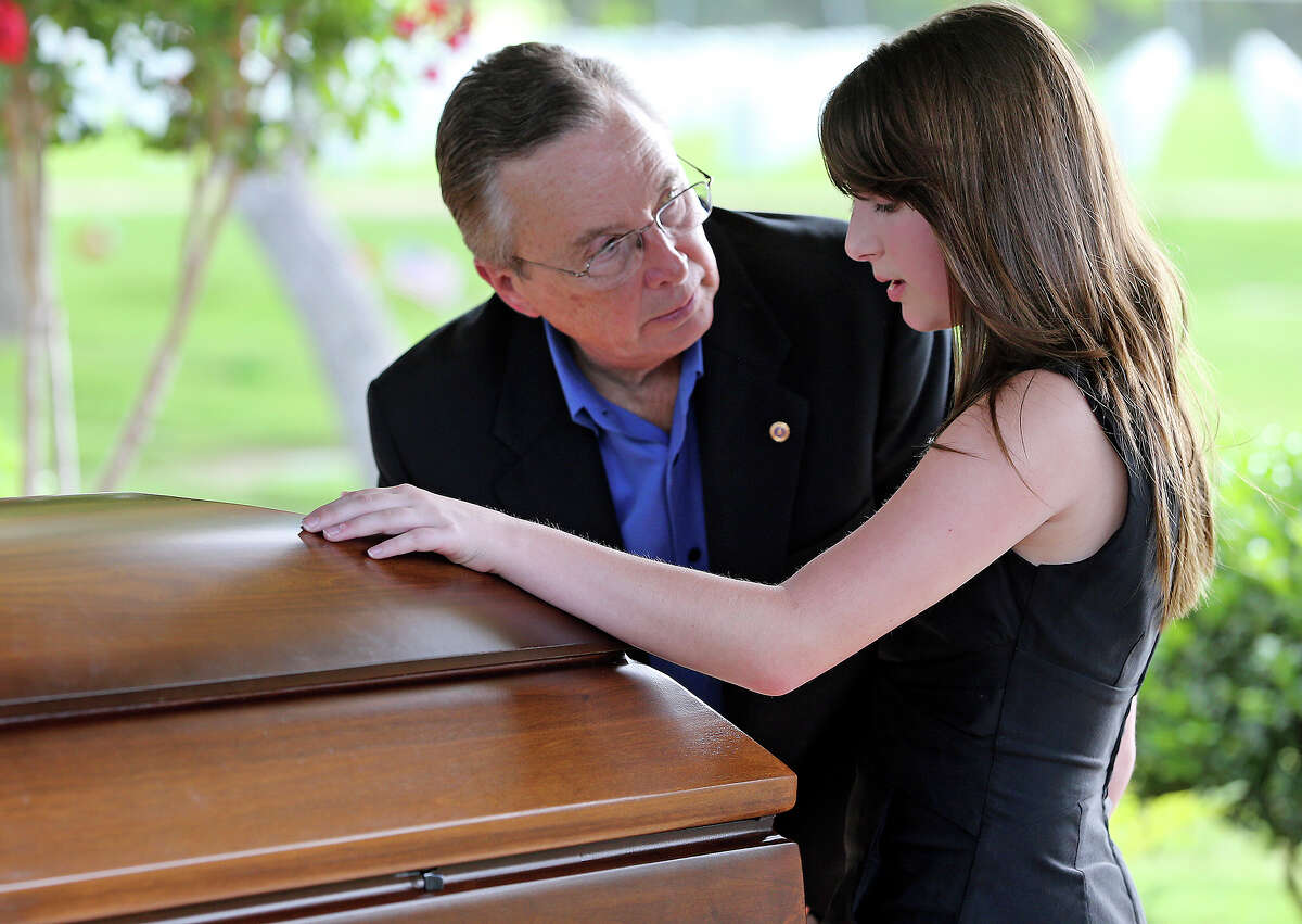 Madison Clark comes forward, with her grandfather Paul Wuenstel and touches the casket of her father as Lt. Col.Todd J. Clark is honored in burial services at Fort Sam Houston National Cemetery on June 21, 2013.
