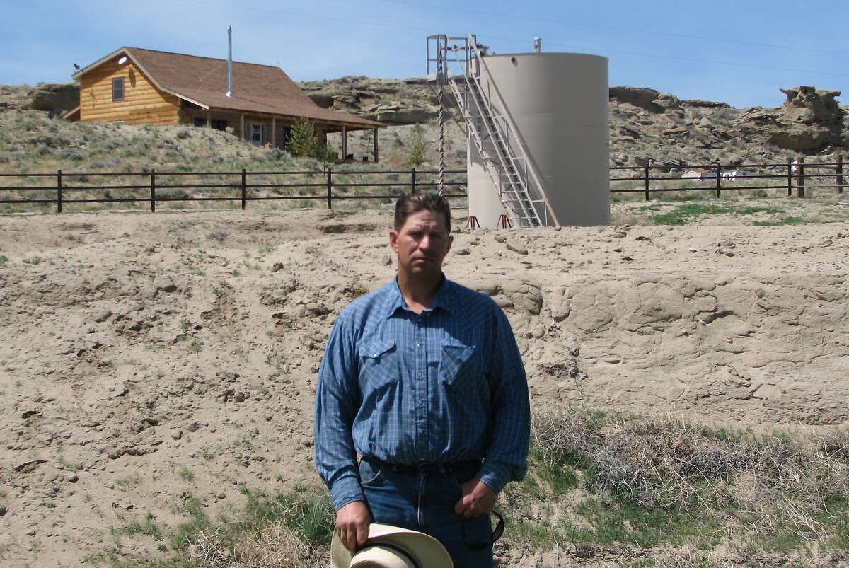 FILE - This May 22, 2009 picture shows John Fenton, a farmer who lives near Pavillion in central Wyoming, near a tank used in natural gas extraction, in background. Fenton and some of his neighbors blame hydraulic fracturing, or "fracking," a common technique used in drilling new oil and gas wells, for fouling their well water. Sen. James Inhofe and colleagues will ask EPA Administrator Lisa Jackson in a letter Friday Jan. 20, 2012 to formally raise the profile of the EPA draft study linking fracking and groundwater pollution in Wyoming.(AP Photo/Bob Moen, File)
