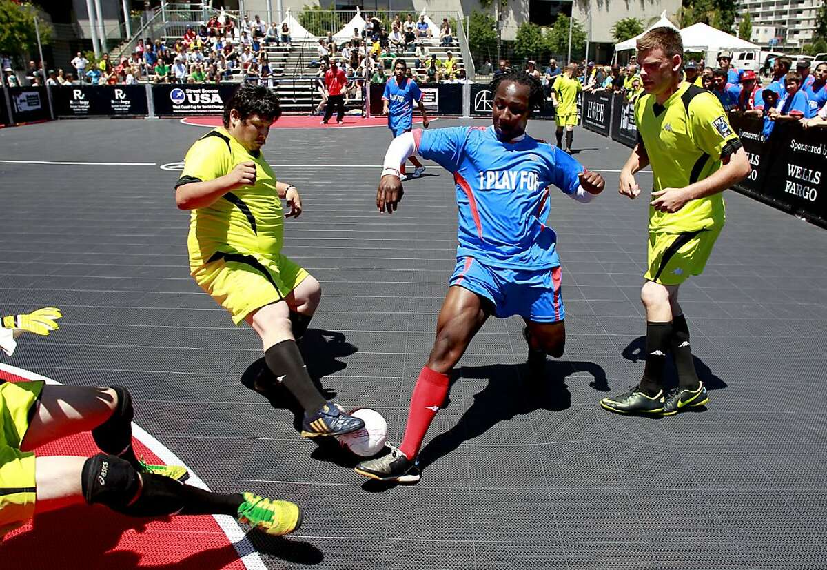 Ablaza Grant of the Street Soccer San Francisco team, dribbles a few defenders of the Sacramento Mohawks during the first annual USA West Coast Cup at Justin Herman Plaza in San Francisco, Calif. Street Soccer USA uses the power of soccer to help homeless men and women dramatically transform their lives. We utilize the power of sports, in this case soccer, to promote player development not merely on the field, but in every aspect of life.