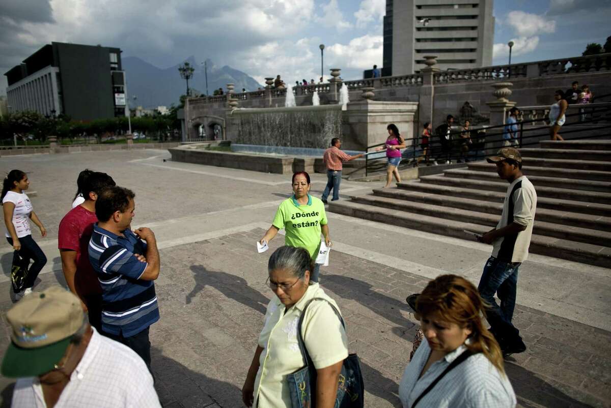 Rosa González (center) hands out fliers about the disappearance of her daughter more than two years ago in Monterrey.