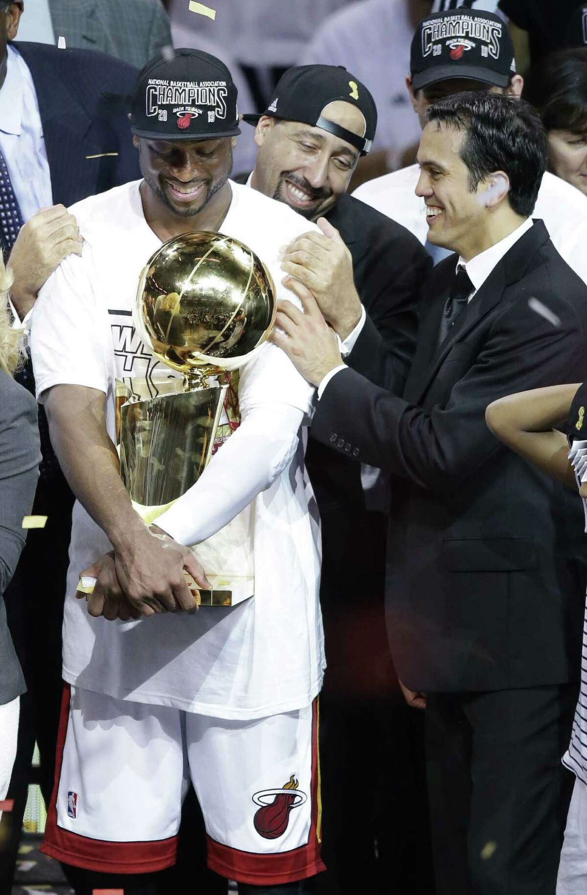 Miami's Dwyane Wade smiles as he holds the Larry O'Brien trophy for the third time in his career. During Game 7 on Thursday, the star guard overcame serious knee problems and scored 23 points in 39 minutes.