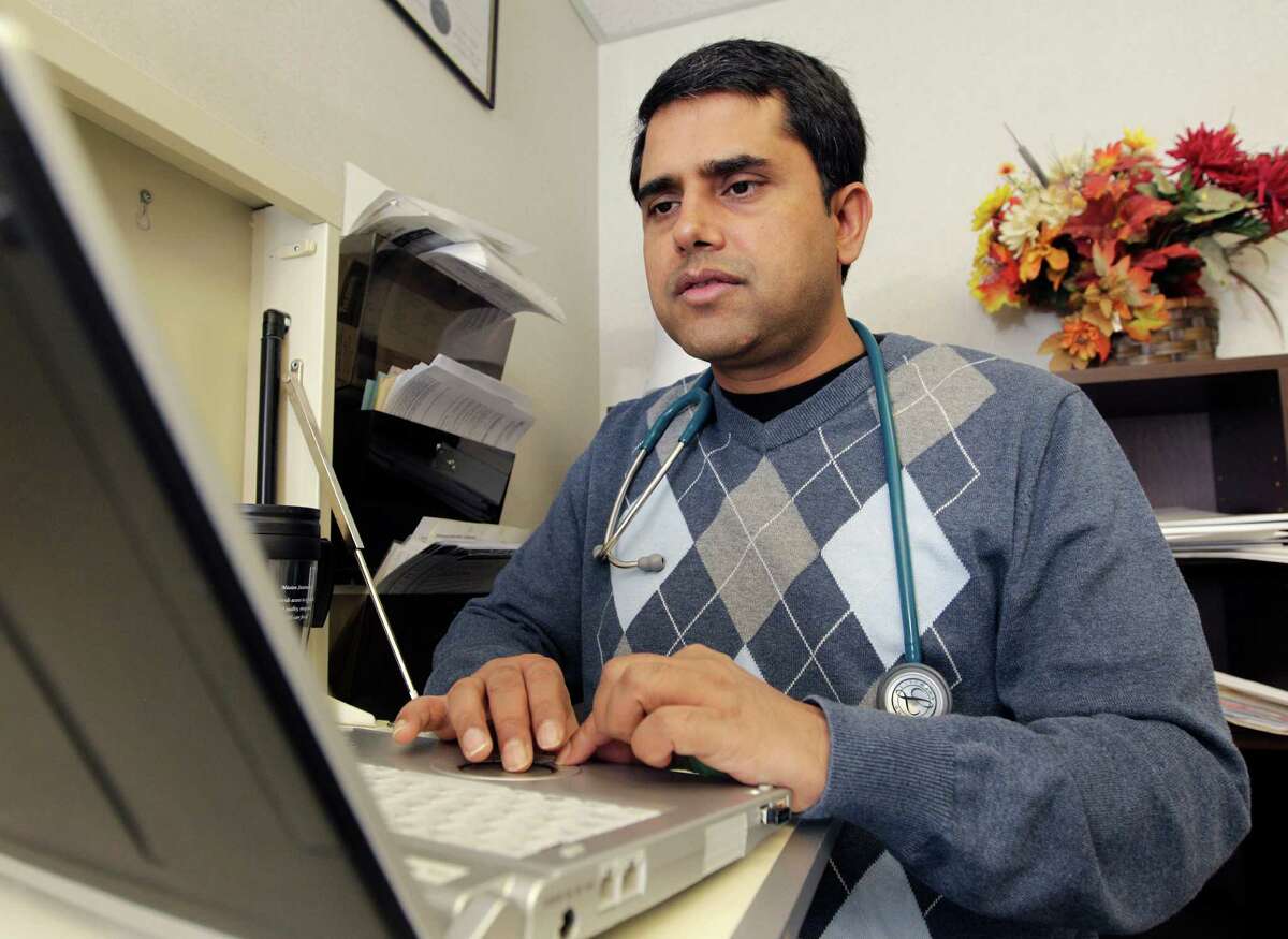 In this Thursday, March 28, 2013 photo, Dr. Damodar Poudel works on patient records at Family Healthcare Inc., in Chillicothe, Ohio. A shortage of primary care physicians in parts of the country is expected to worsen as millions of newly-insured Americans gain coverage under the federal health care law next year. (AP Photo/Jay LaPrete)