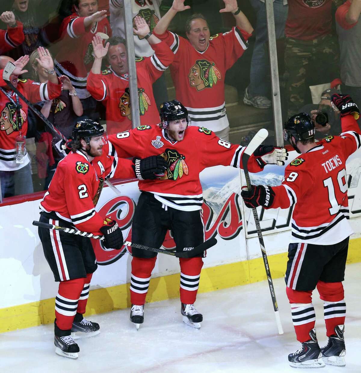 Chicago's Patrick Kane leads the cheers with help from teammates Duncan Keith (2) and Jonathan Toews (19) after scoring his second goal in the second period.