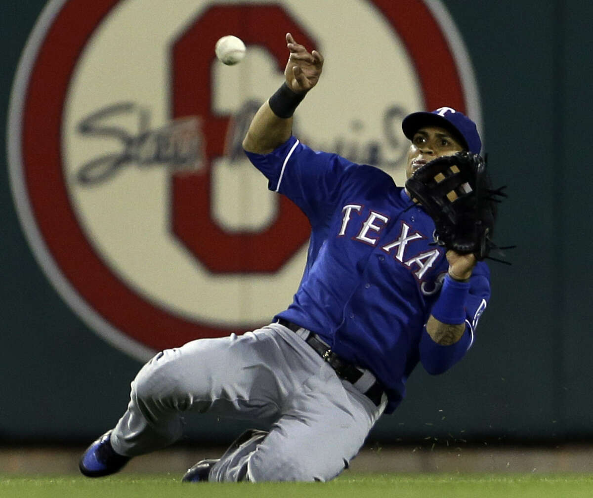 Rangers center fielder Leonys Martin slides to catch a ball off the bat of the Cardinals' Carlos Beltran to end the fifth inning. Martin had two hits to help Texas win.