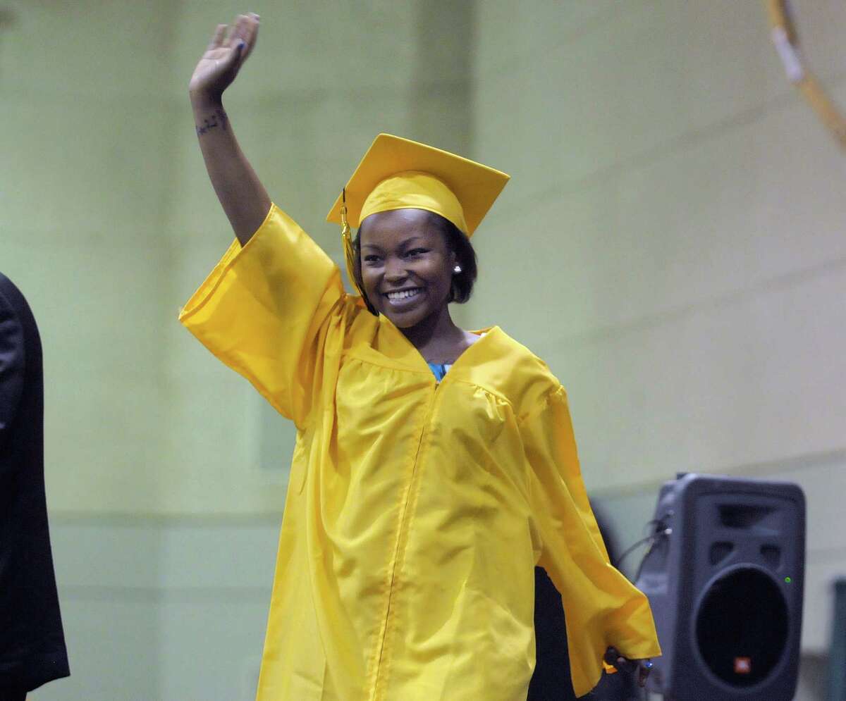 Graduate Linnie Bryant waves to the crowd as she walks onto the stage to get her diploma during the Troy High School graduation ceremony at Hudson Valley Community College on Sunday, June 23, 2013 in Troy, NY. (Paul Buckowski / Times Union)