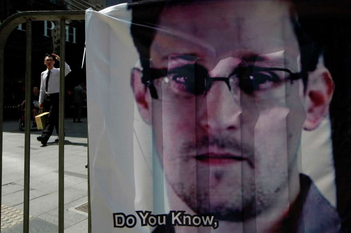 FILE - In this June 21, 2013 file photo, a banner supporting Edward Snowden, a former CIA employee who leaked top-secret documents about sweeping U.S. surveillance programs, is displayed at Central, Hong Kong's business district. The Hong Kong government says Snowden wanted by the U.S. for revealing two highly classified surveillance programs has left for a "third country." The South China Morning Post reported Sunday, June 23, 2013 that Snowden was on a plane for Moscow, but that Russia was not his final destination. Snowden has talked of seeking asylum in Iceland. (AP Photo/Kin Cheung, File)