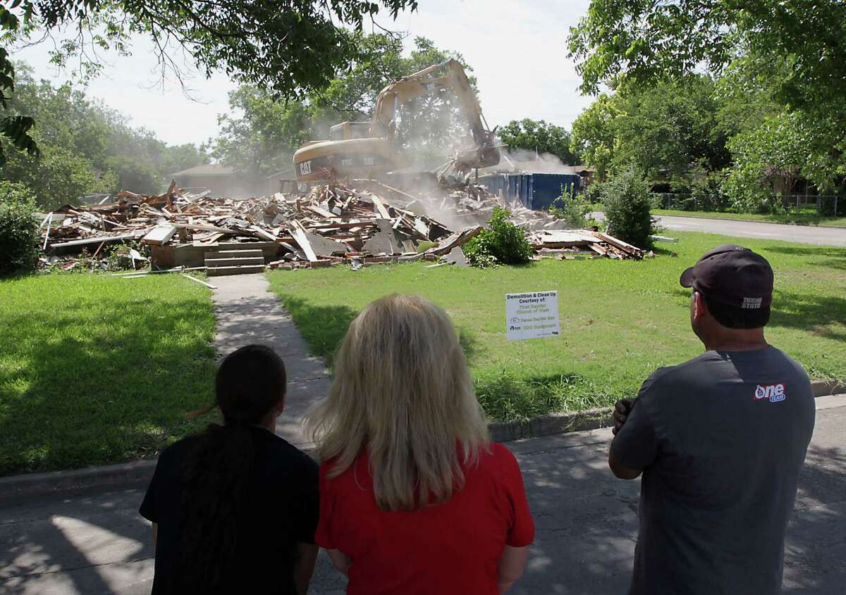 Debbie Keel, center, watches this month as her childhood home is demolished with daughter Brooke Keel, left, and husband Ernie Keel. The home was damaged in the fatal April blast at West Fertilizer Co. "If it was just gone, we could move on," she said.