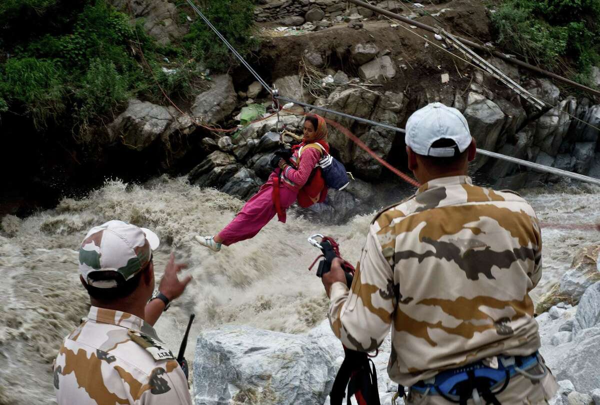 A stranded Indian pilgrim is transported across a river using a rope rescue system by Indo-Tibetan Border Police personnel on Sunday.