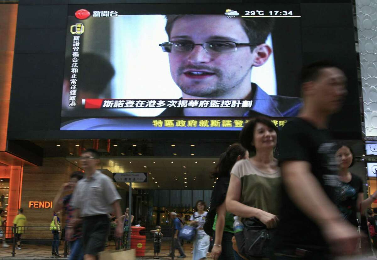 A TV screen shows a news report of Edward Snowden, a former CIA employee who leaked top-secret documents.