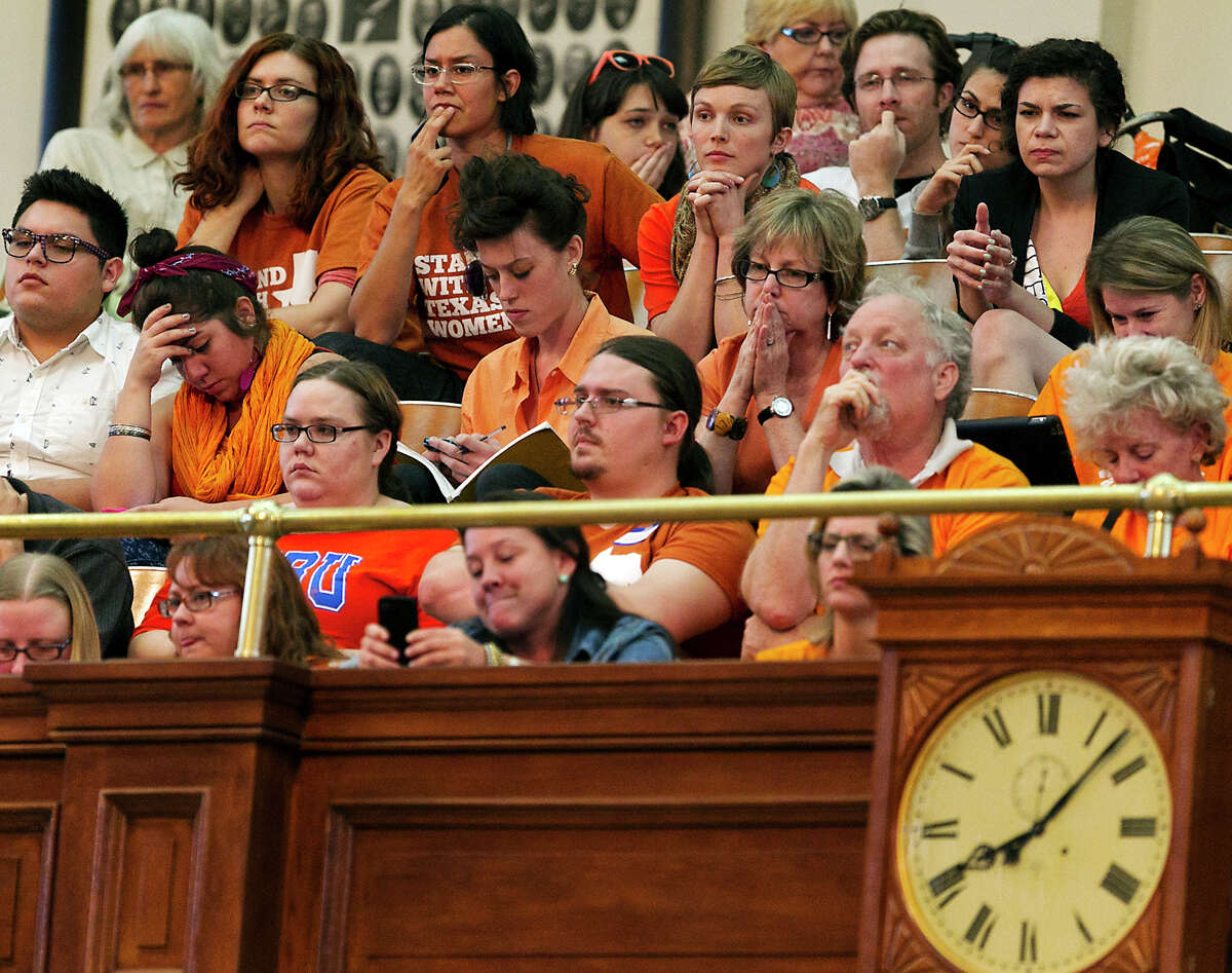 Women's rights protesters react in gallery of the House of Representative Chambers as State Rep. Jodie Laubenberg, R-Parker, works on the second reading of Senate Bill 5, the bill she sponsored, during debate on abortion held on the House floor of the State Capitol in Austin, Texas, on Sunday, June 23, 2013. If passed, the bill would ban abortions after 20 weeks, require that they take place in surgical centers, and restrict where and when women can take abortion-inducing pills_and force 37 out of 42 abortion clinics in Texas to close and undergo millions of dollars in upgrades. (AP Photo/Statesman.com, Rodolfo Gonzalez)