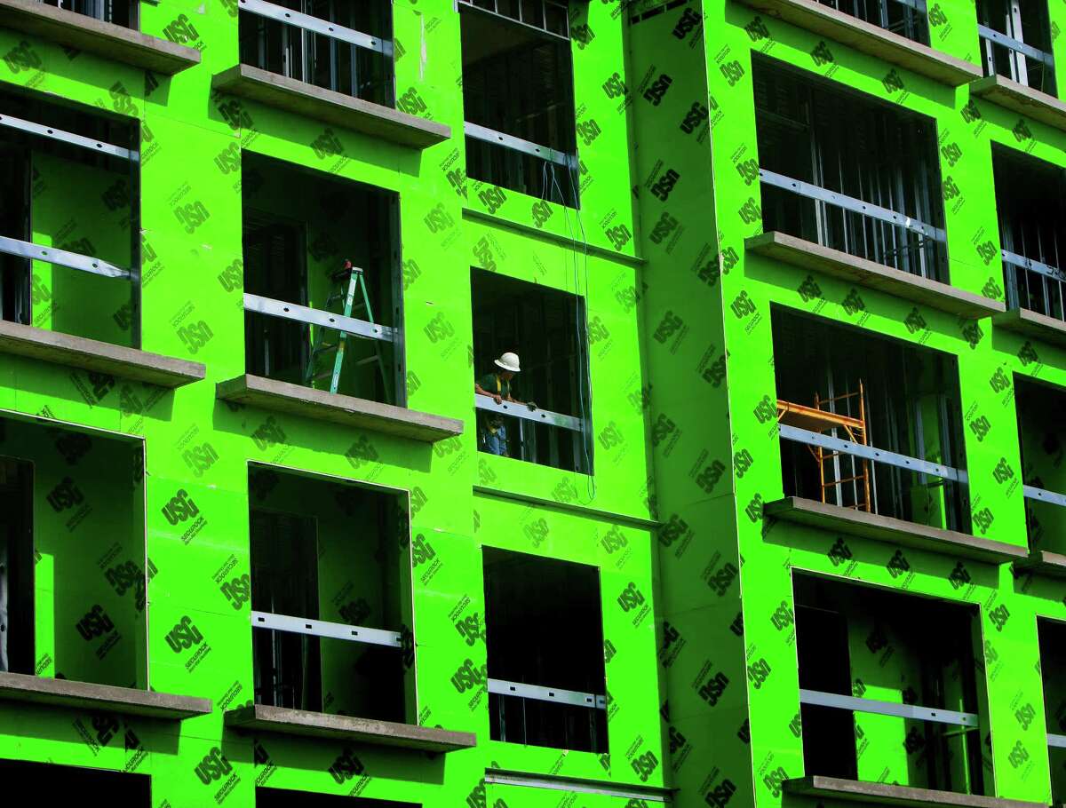 A man works to finish an apartment complex in the 2900 block of Dallas Street, Monday, June 24, 2013, in Houston. (Cody Duty / Houston Chronicle)