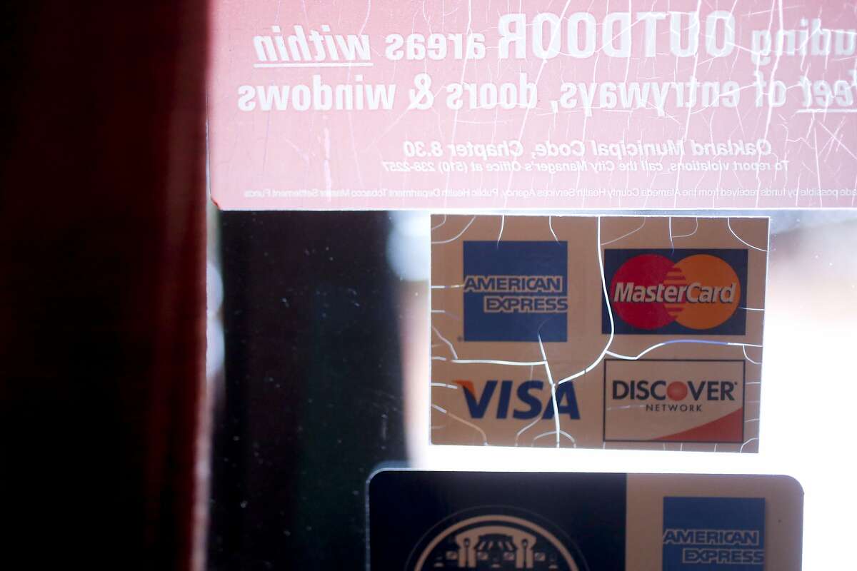 An accepted credit cards sign on the window of Italian Colors, a restaurant in Oakland's Montclair area, that is a part of a class action lawsuit against American Express in Oakland, Calif. on June 25, 2013.