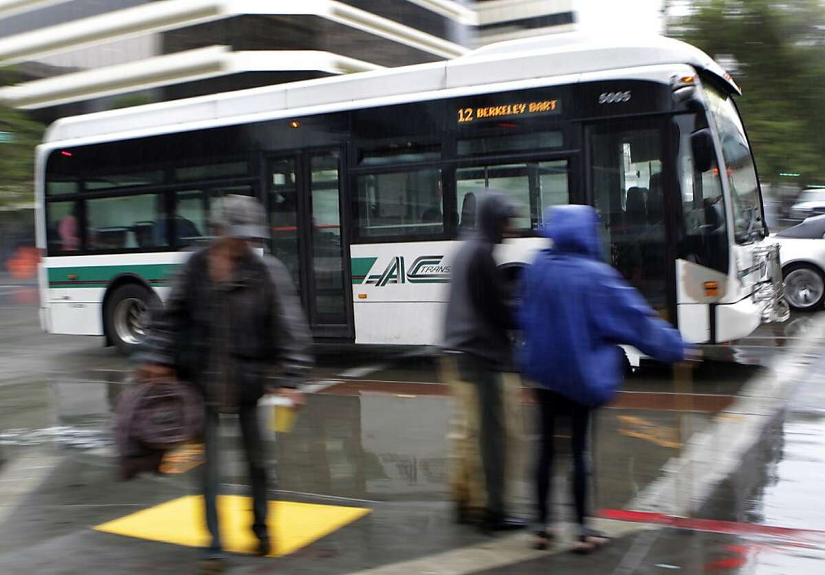 An AC Transit bus crosses 14th Street on Broadway in downtown Oakland, Calif. on Tuesday, June 25, 2013. Employees from both AC Transit could walk off the job Wednesday.