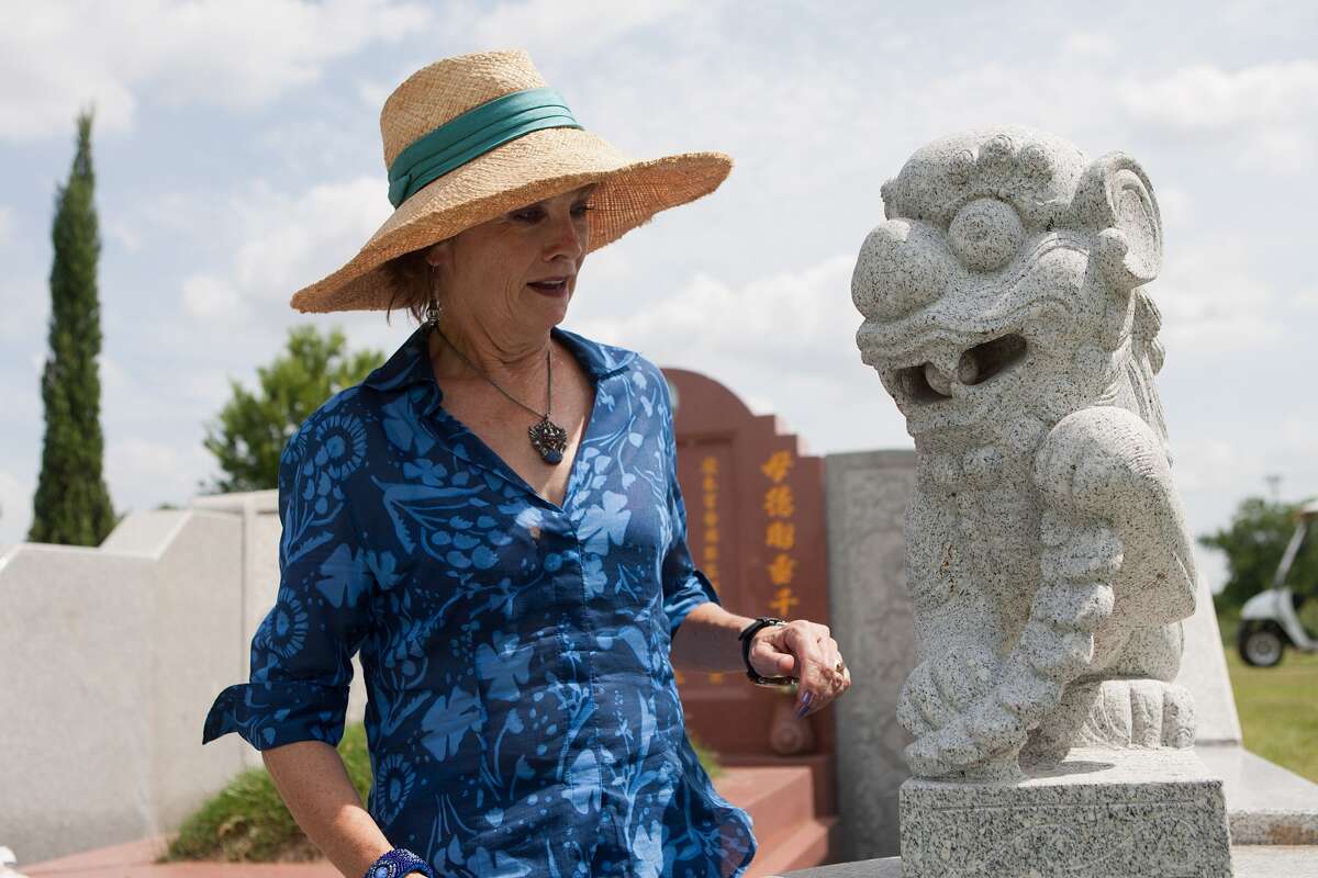 Barbara Hinton looks at a dog guarding Thanh Kim Tran's tomb at Hollywood Historic Cemetery.