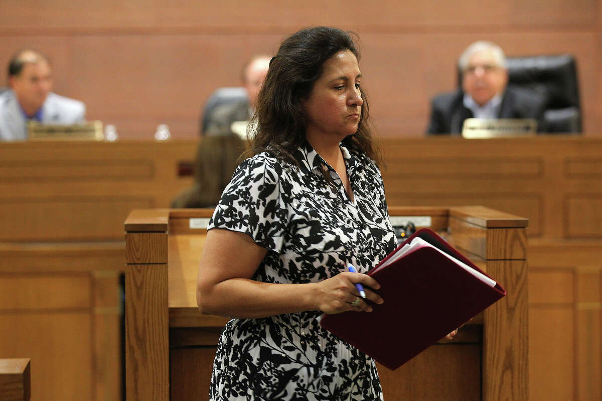 Espada Road resident Celia Olivarez leaves the podium after speaking during a Special Bexar County Commissioners Court meeting, Tuesday, June 25, 2013. The San Antonio River Authority provided the court with information on the causes of the flooding in the Espada Road neighborhood on May 25. Options were presented during the meeting that include the standard flood plain buy-out program.