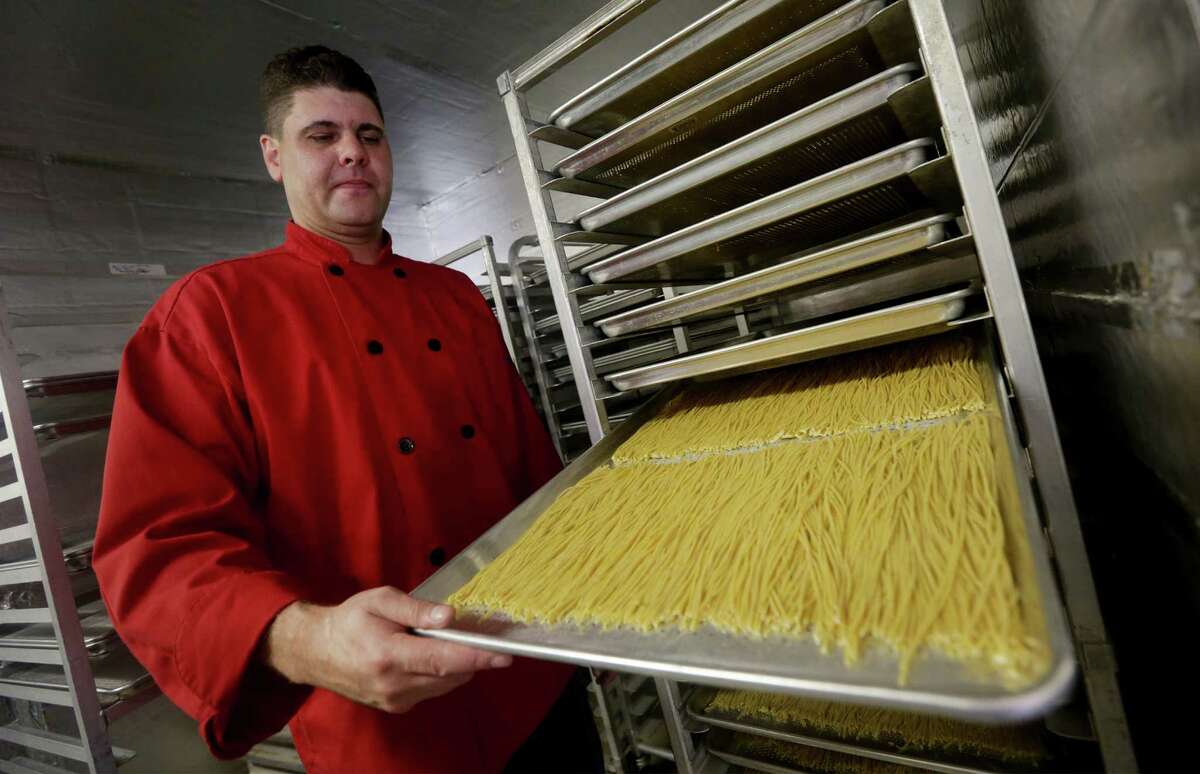 Wayne Lowery, owner of Shayne Sauce Foods, shows a tray of his black pepper whole wheat pasta setting out to dry. The company claims to be one of the largest makers of whole-wheat pastas, which come in a variety of flavors, on Monday, June 24, 2013.
