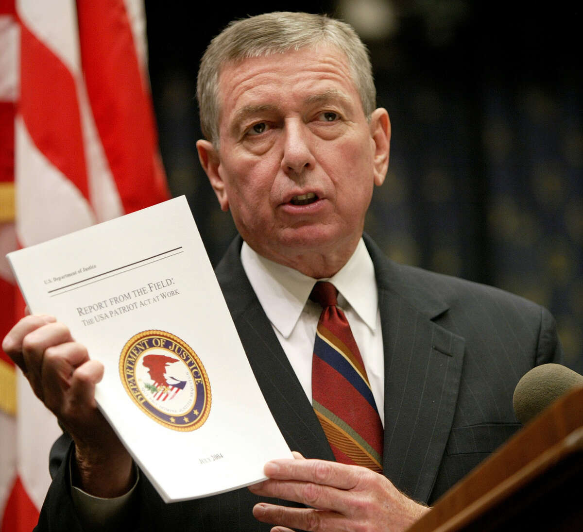 U.S. Attorney General John Ashcroft holds up a copy of "Report from the Field: The USA Patriot Act at Work" during a news conference on July 13, 2004 in Washington. Ashcroft is likely to leave his post before the start of President Bush's second term, senior aides said Thursday Nov. 4, 2004. (AP Photo/Evan Vucci)