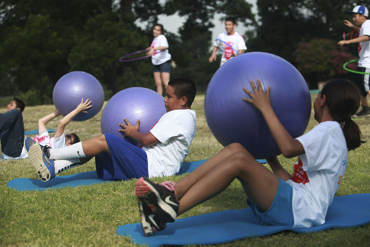 Youths participate in fitness activities at Roosevelt Park, where it was announced that the Coca-Cola Foundation is giving $1.5 million in grants to San Antonio Sports and the San Antonio Food Bank for several initiatives to improve the city's health.