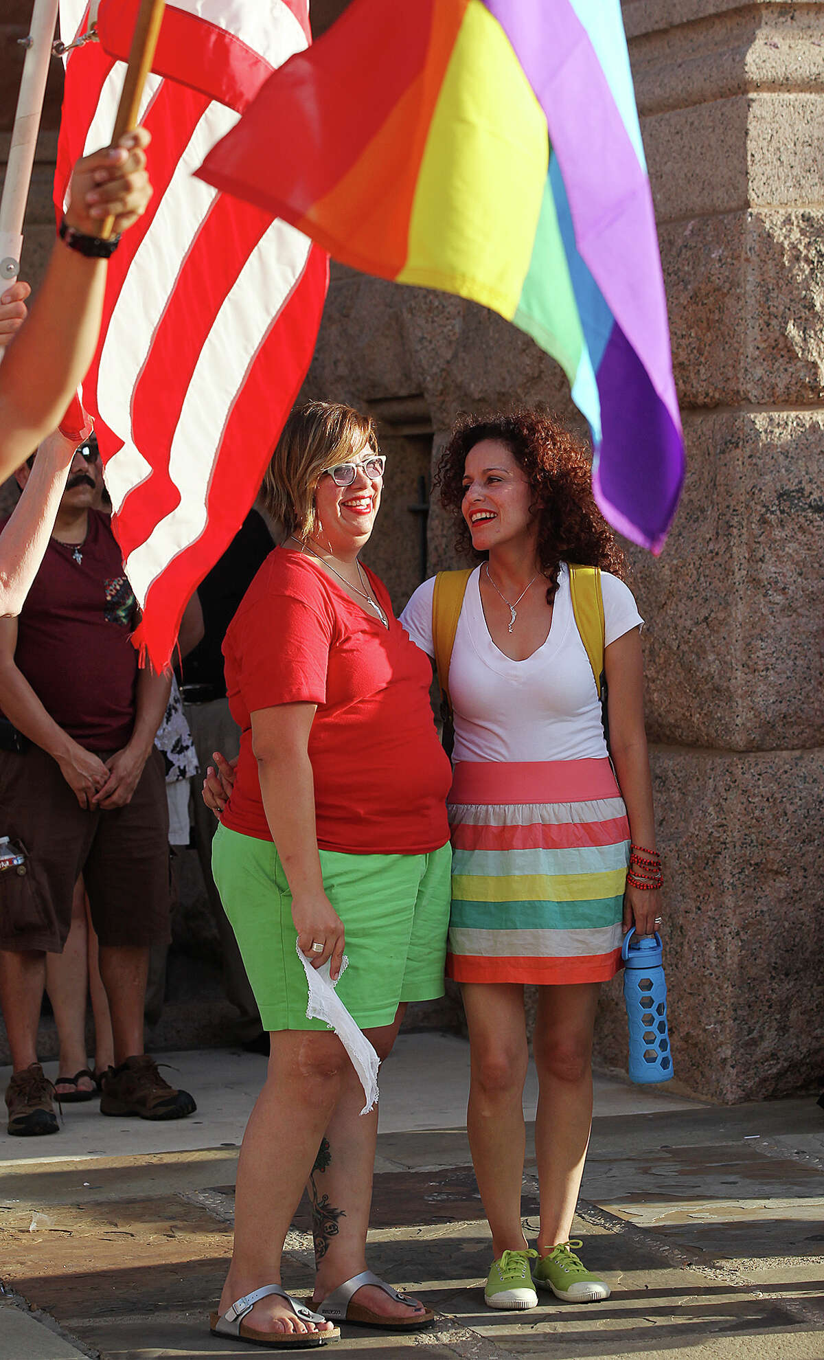Anel Flores, left, and Erika Casasola gather with other supporters for "The Day of Decision" Rally in front of the Bexar County Courthouse, Wednesday, June 26, 2013. The rally was in celebration of the U.S. Supreme Court decision striking down the Defense of Marriage Act. It was organized by the Local Human Rights Campaign and GetEQUAL TX. Flores and Casasola have been together for eight years.