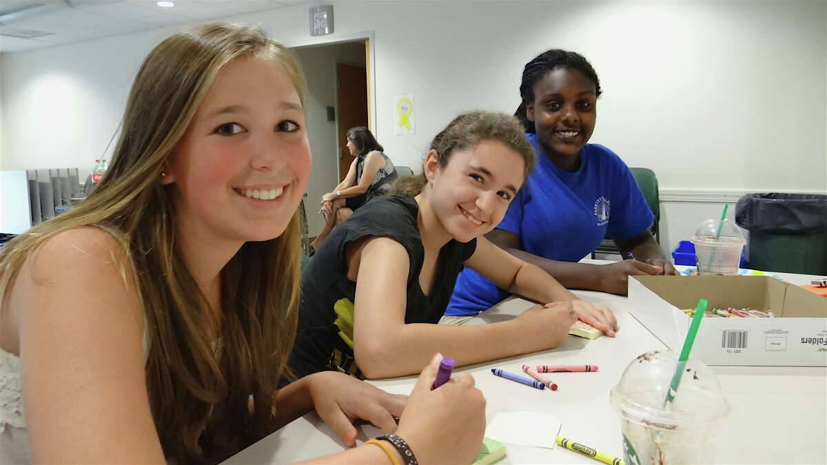 Fairfielders Isabella Huban, 13; Anna Ciraulo, 12, and Maya Vetrosky, 13, draw designs for a Post-It Gallery at Fairfield Library's Teen Summer Challenge kickoff on June 26.