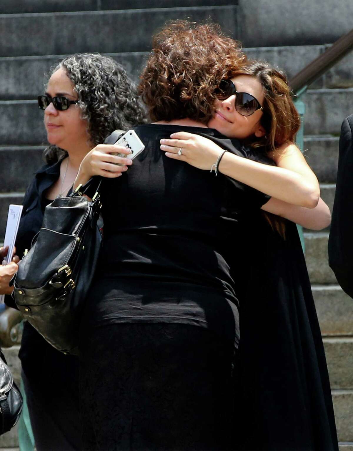 Actress Jamie Lynn Sigler, right, is embraced as she leaves the Cathedral Church of Saint John the Divine after the funeral service for James Gandolfini, Thursday, June 27, 2013 in New York. Gandolfini, who played Tony Soprano in the HBO show "The Sopranos", died while vacationing in Italy last week.